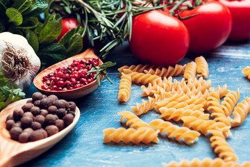 Pasta spaghetti, vegetables and spices, on wooden table