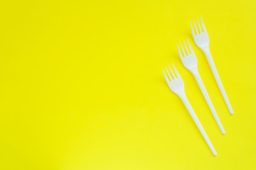 Disposable plastic plugs on bright yellow background with copy space.