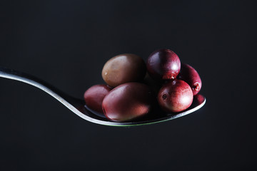 A spoon full of black olives