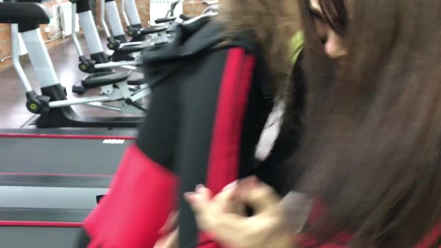 Two beautiful sexy women in sports uniform in gym. communicate and have fun discussing