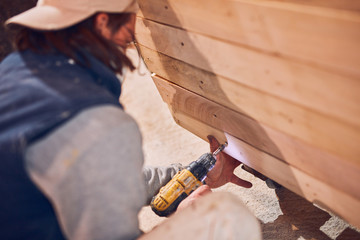 Male carpenter working on old wood in a retro vintage workshop.