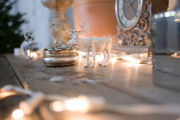 Fototapeta na wymiar vintage table clock. Vintage interior decor. Gold watches, flashlights, home decoration. Christmas interior. Deer head, candles, porcelain decor.