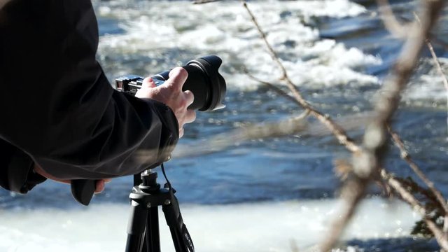 photographer taking photos of frozen creek in the northern sweden