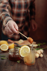 Ginger tea with honey , lemon and mint on old wooden table .