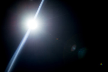 Flash of a distant abstract star. Abstract sun flare. The lens flare is subject to digital correction.