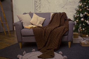 books and pillows are on the sofa. The reading area. Warm cozy interior in brown and grey tones.