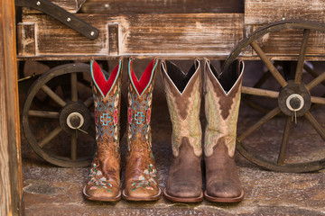 Pair of cowboy boots in front of wooden wagon