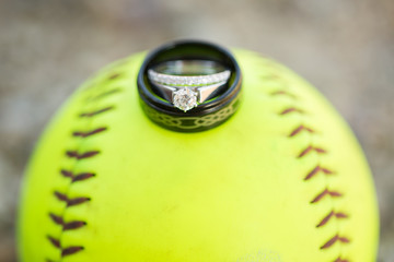 Wedding rings on top of a yellow softball