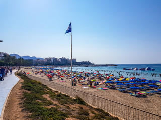 Poniente beach of Benidorm in summer with the flag that indicates European blue beach of better...