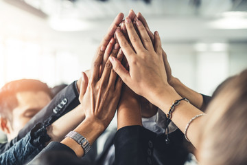 Many happy business people raise hands together with joy and success. Company employee celebrate after finishing successful work project. Corporate partnership and achievement concept. - obrazy, fototapety, plakaty