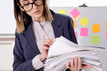 Young female employee in conflicting priorities concept