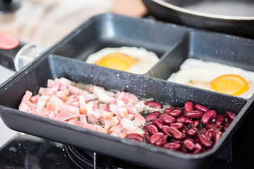 English tastefull breakfast with fried bacon, beans and eggs