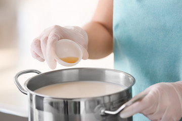 Woman preparing tasty cheese in kitchen, closeup