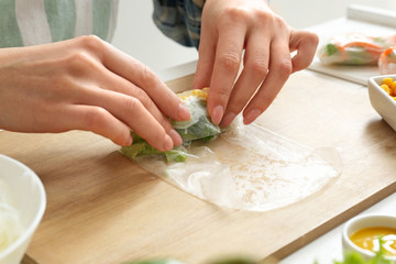 Obraz na płótnie Canvas Woman preparing tasty spring rolls, closeup