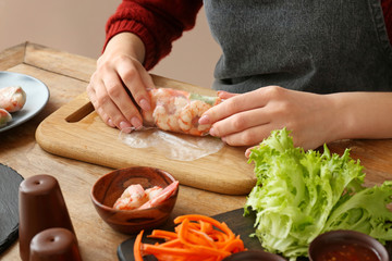 Woman preparing tasty spring rolls, closeup