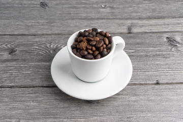 Coffee cup and coffee beans on wooden background. Top view and selective focus