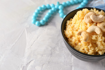 Bowl with traditional Indian food pongal on table