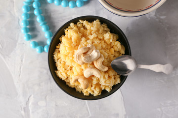 Bowl with traditional Indian food pongal on table