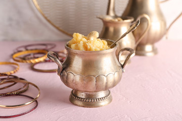 Pot with traditional Indian food pongal on table