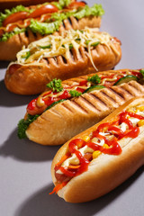 Tasty hot dogs on grey background