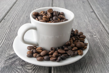 Coffee cup and coffee beans on wooden background. Top view and selective focus