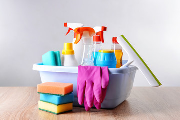 Set of cleaning supplies on table against light background