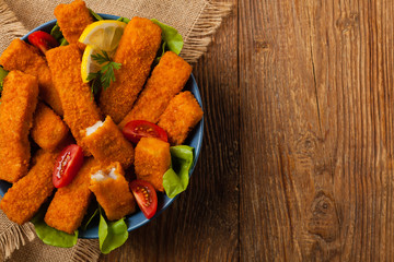 Fish sticks with salad in blue bowl.
