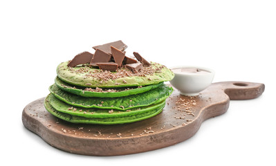 Tasty green pancakes with chocolate on white background
