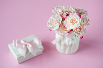 English roses on pink background with gift box. Postcard concept. Happy Mother's Day, Women's Day or Birthday. Minimalism, selective focus.