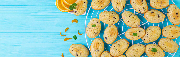 Homemade cookies. French cookies Madeleines with orange juice and chocolate chips. Banner. Top view