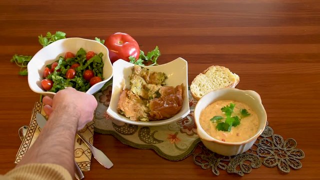 Healthy mediterranean cuisine, three dishes concept for lunch or dinner. Side view closeup of placing the letuce salad on the table