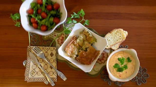 Healthy mediterranean cuisine, three dishes concept for lunch or dinner. Closeup of getting the letuce salad from the table