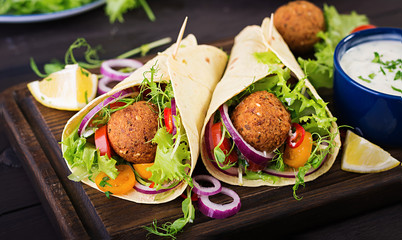 Tortilla wrap with falafel and fresh salad. Vegan tacos. Vegetarian healthy food. - Powered by Adobe