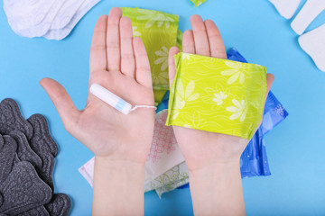 Fototapeta premium Man hands giving hygiene product. Sanitary tampon and napkin. Make your selection. Choose your side.