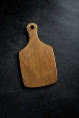 An empty wooden tray on a black background