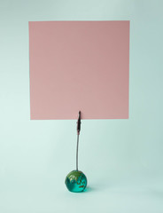 Note sheet inscriptions. Pink, blue, filet paper on a clothespin holder on white background, text space. Place for inscription.