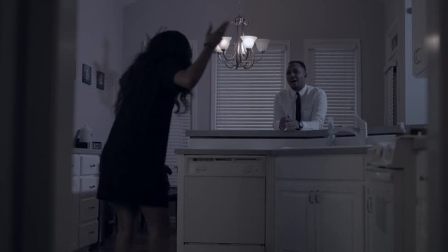 African couple fighting in kitchen late at night