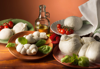 still life with mozzarella cheese ,olive oil ,tomato and basil on the wooden table