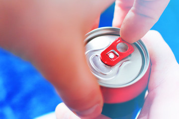 a man is going to open an aluminum can of beer with his left hand, close-up