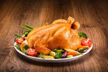 Roasted chicken with vegetables on a wooden table