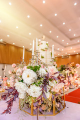wedding cake with Decorated with flowers and Candlestick at marriage ceremony