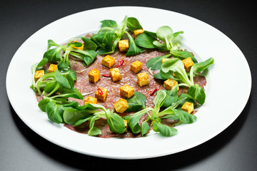 Soup of mashed potatoes with crackers and herbs on a white background on a white background.