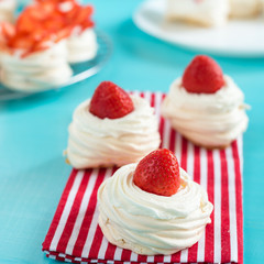 Beautiful pavlova cakes with strawberries on a blue background. Selective focus. Tasty sweet breackfast. Wedding morning. Meringue with cream.