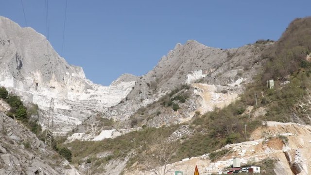 Apuan Alps, Carrara, Tuscany, Italy.  A quarry of white marble. Today workers are helped by mechanical equipment (excavators, diamond wire machines and transport trucks).