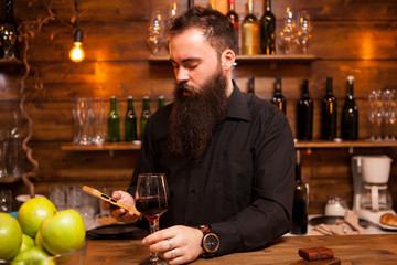 Bartender behind the counter enjoying a glass of wine