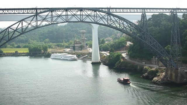Boat Travelling Under a Large Bridge.