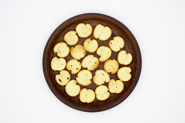 Bake Rolls. The mini bread chips on the brown bowl. Isolated on white background.