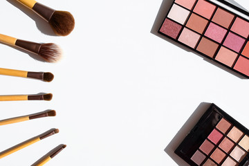 View from above on make up cosmetics - eye shadow palettes and accessories - natural brushes with...