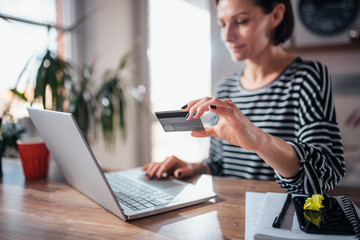 Woman shopping online and using credit card