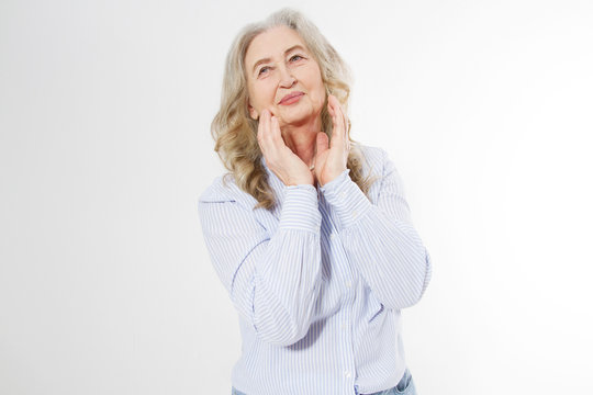 Closeup of smiling senior woman wrinkle face and gray hair. Old mature lady touching her wrinkled skin isolated on white background. Copy space